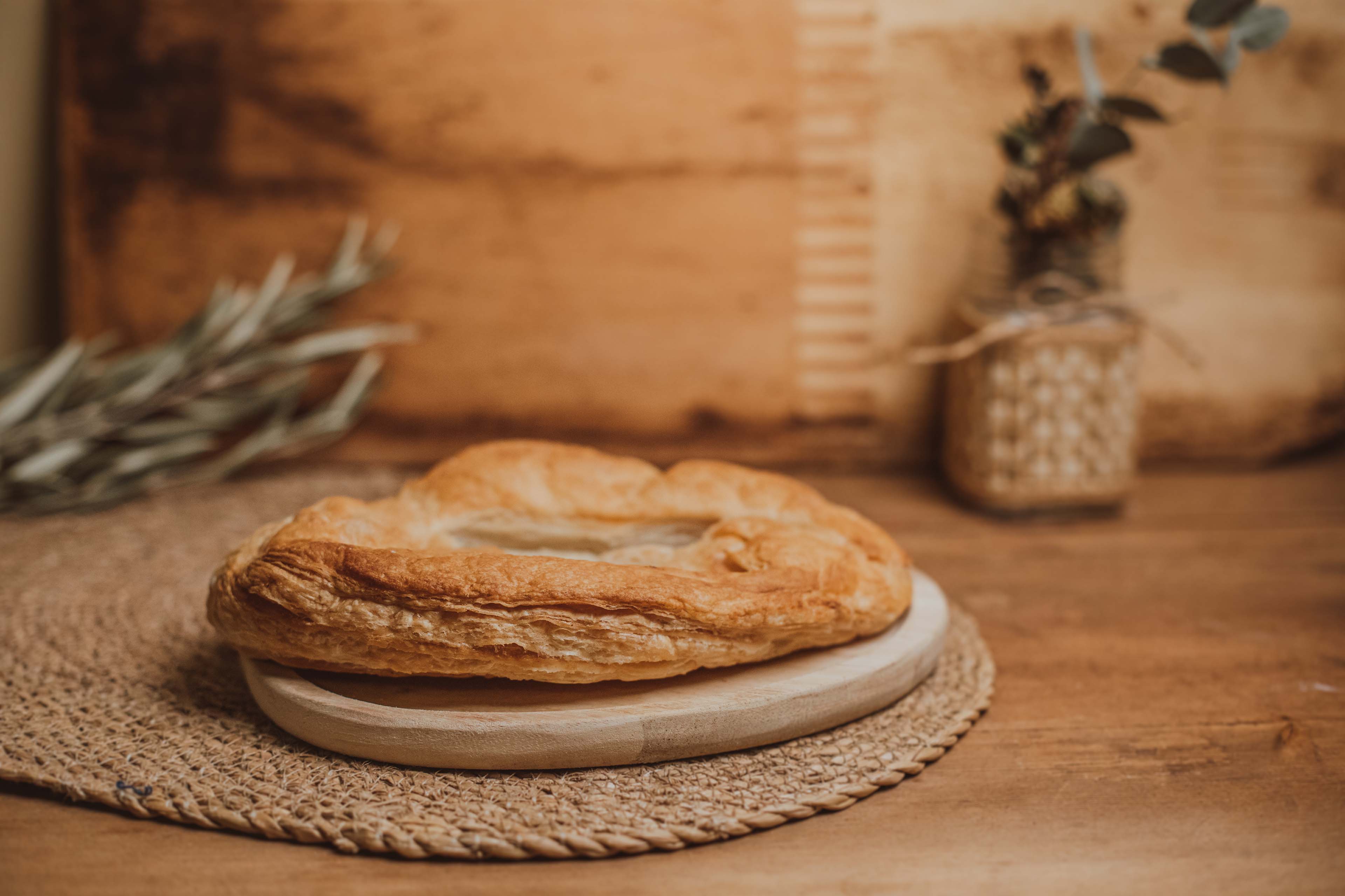 Torta de hojaldre salada en tabla de madera y otros detalles.